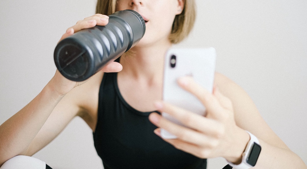 Woman looking at phone and wearing a health watch