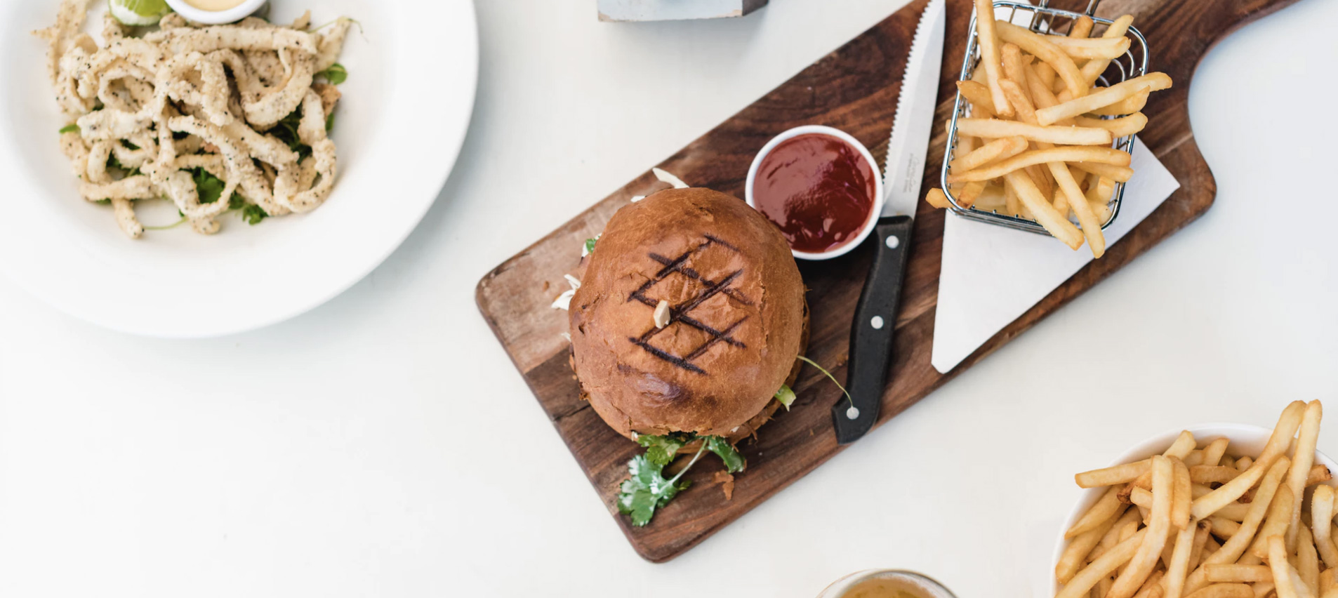 Hamburger, chips and some other food on a table