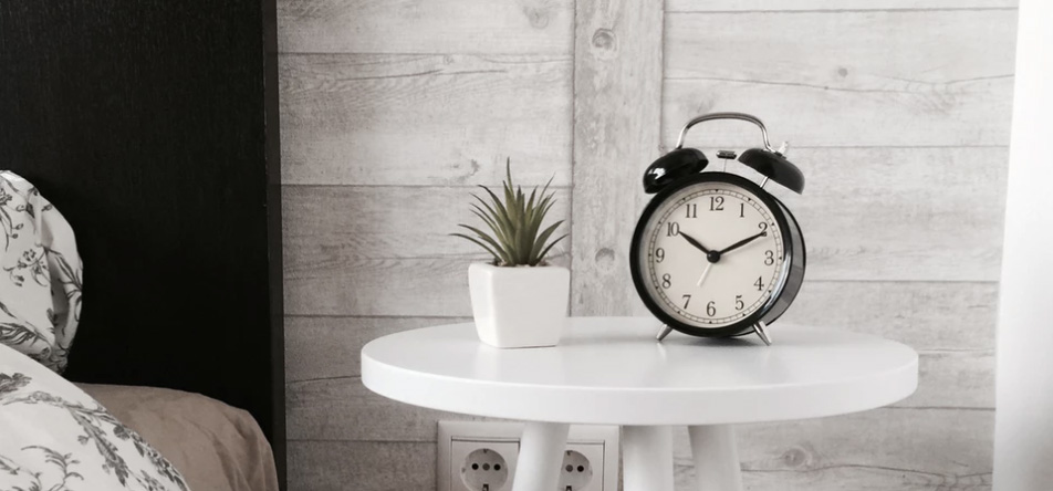 Alarm clock on a small table near the bed