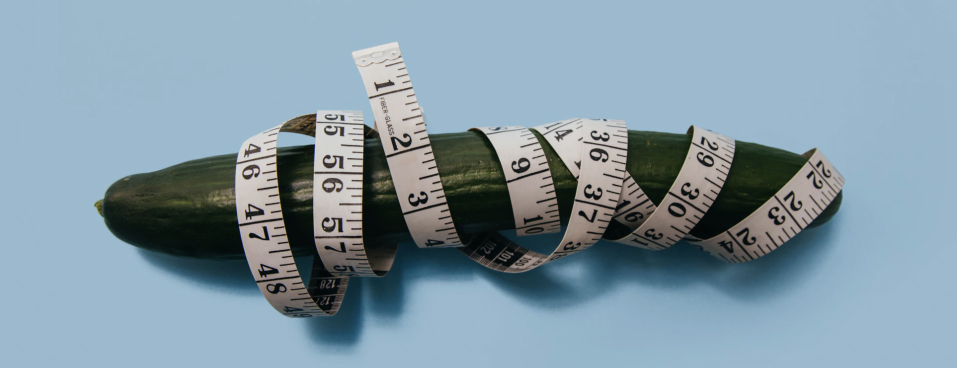 A cucumber with a tape measure around it