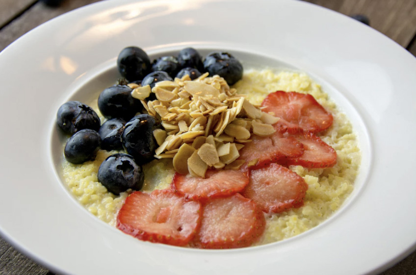 A bowl of porridge with strawberries and blueberries