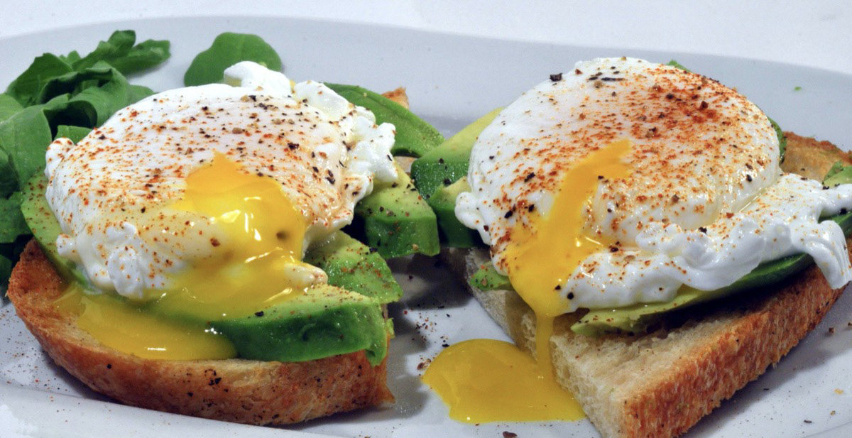 Breakfast sandwich with eggs and avocado. 