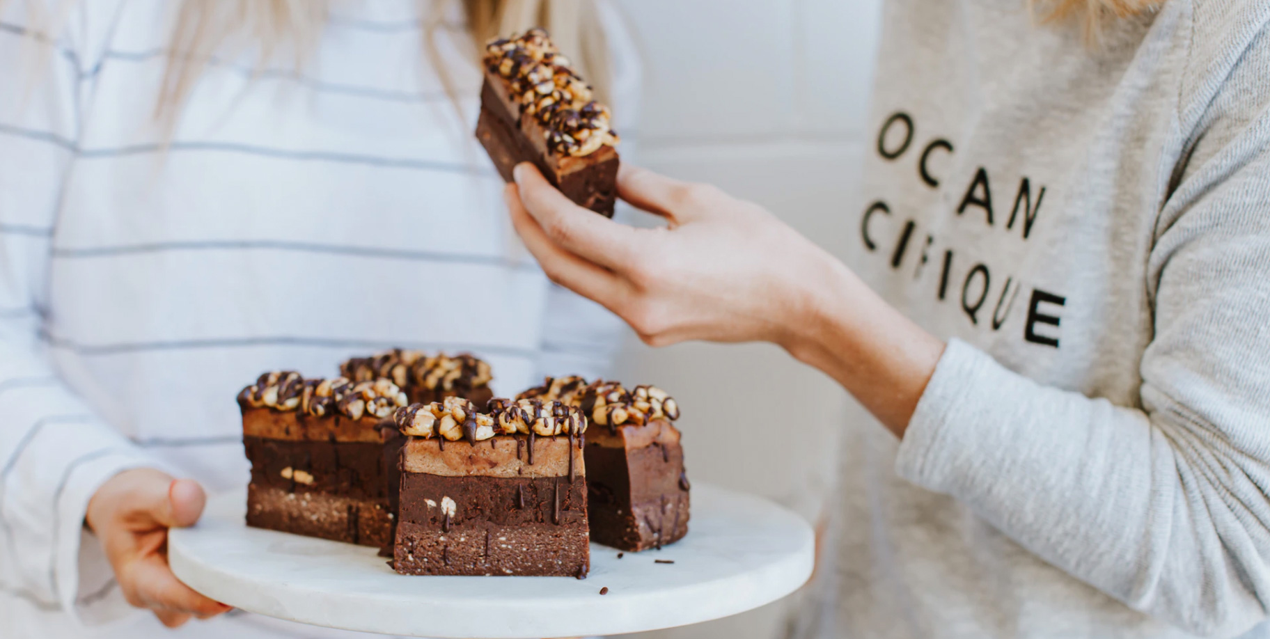 Two women sharing chocolate cake.