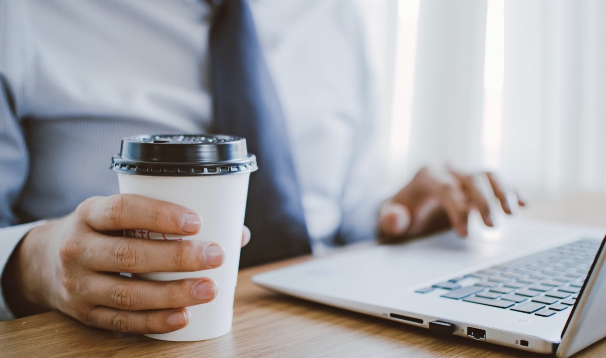 Man drinking coffee and working