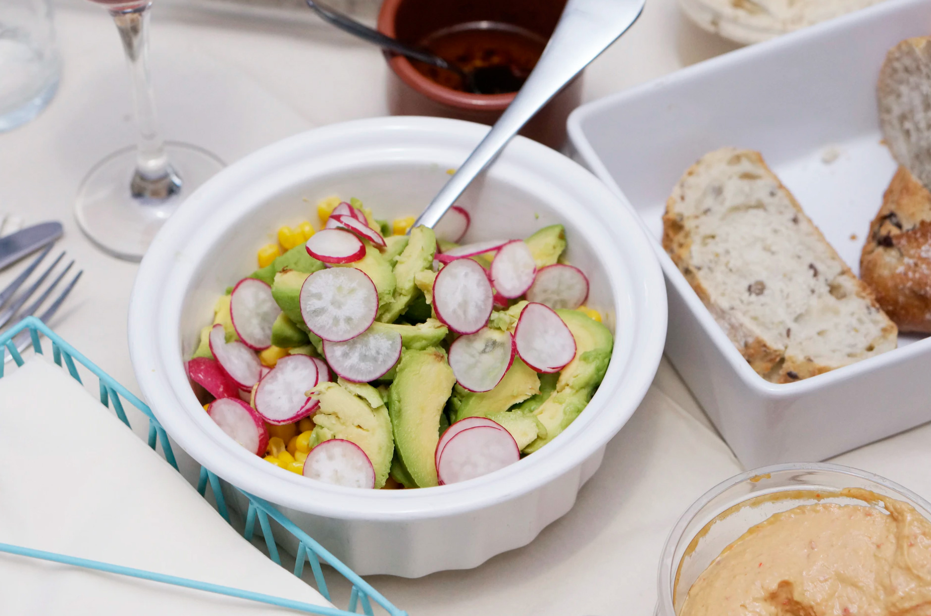 Avocado salad with radish and hummus and homemade bread, image from Unsplash - by Maria Vig