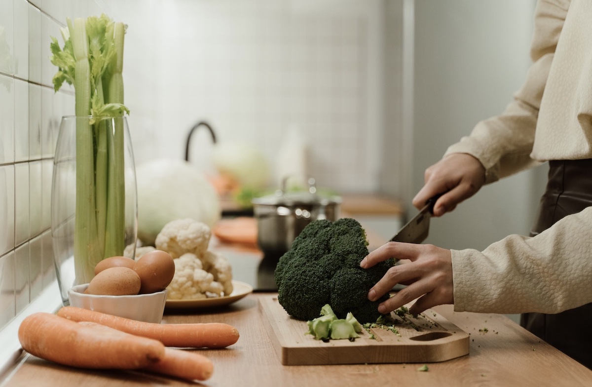 Woman cutting vegetables. Image: Pexels - Ron Lach