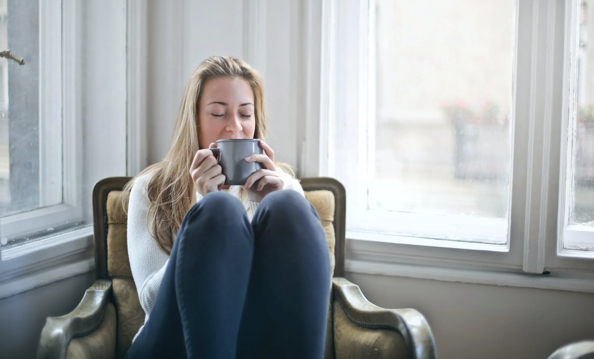 woman drinking tea on chair