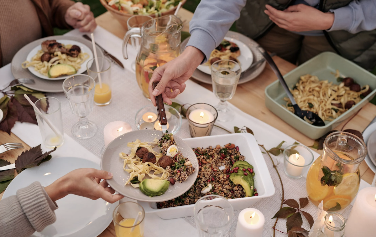 Individuals gathered around table eating together