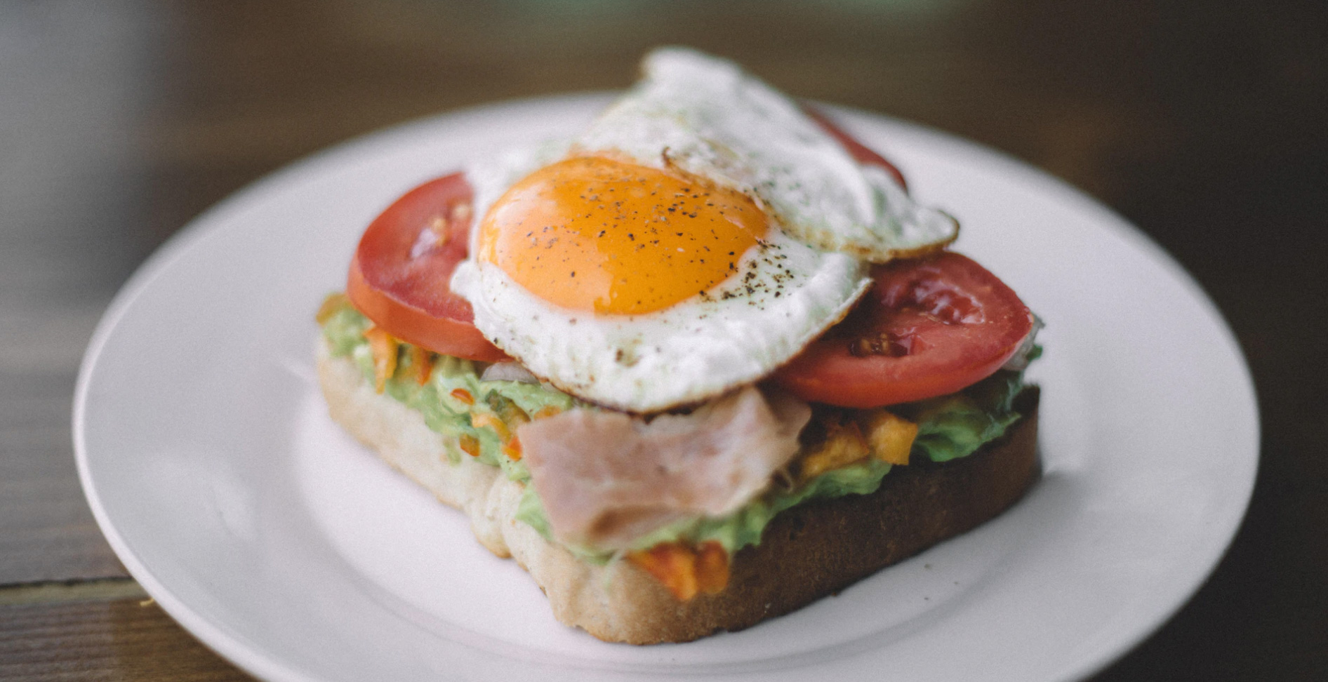 Avocado toast with eggs and tomatoes on a plate