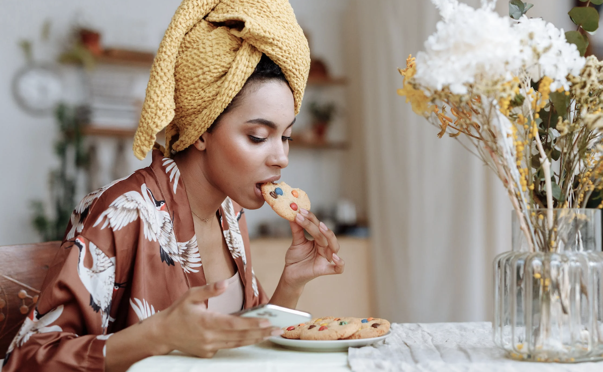 Woman eating while looking at phone