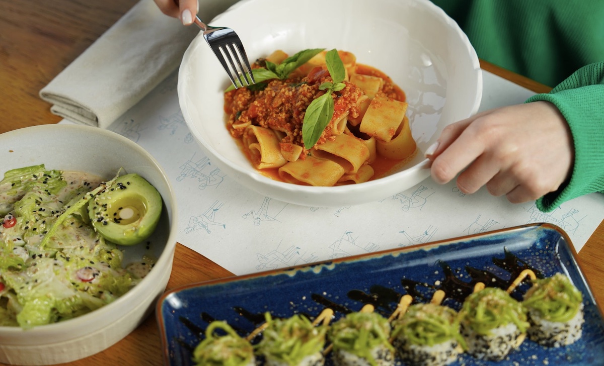 Woman eating a bowl of pasta and sauce 