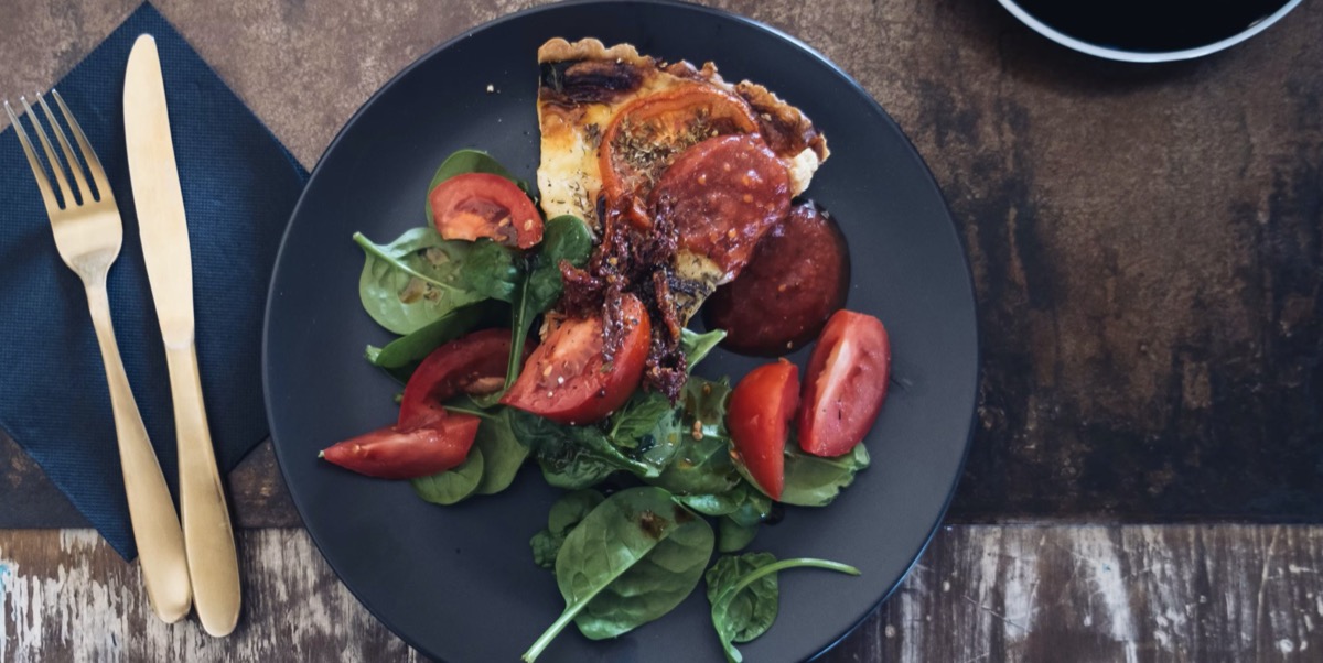 A plate with a slice of pizza and salad