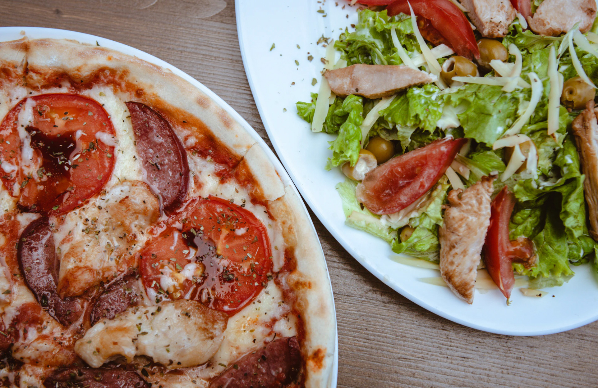 A table with pizza and salad. 