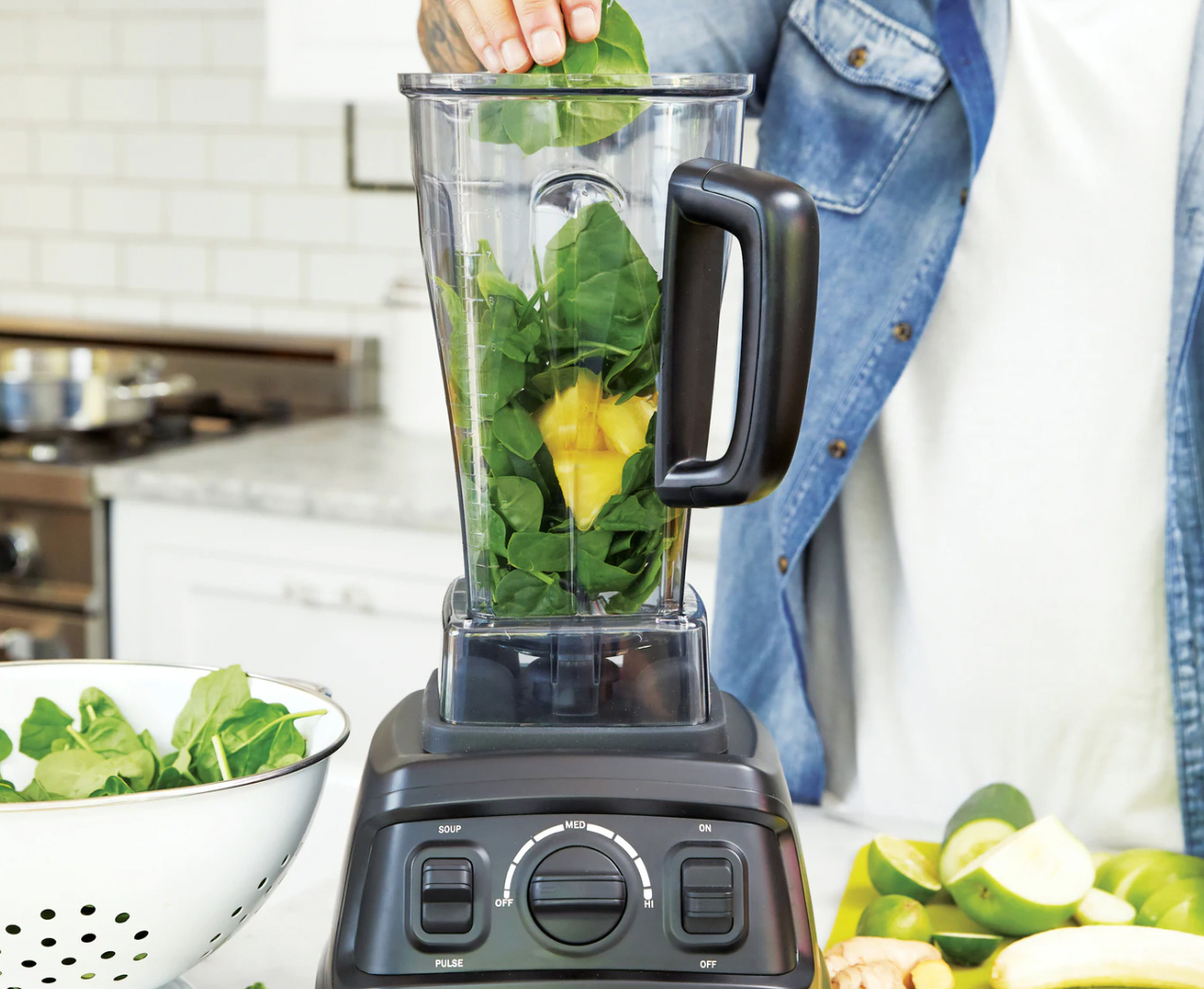 Blender with spinach and fruit to make a smoothie or detox drink