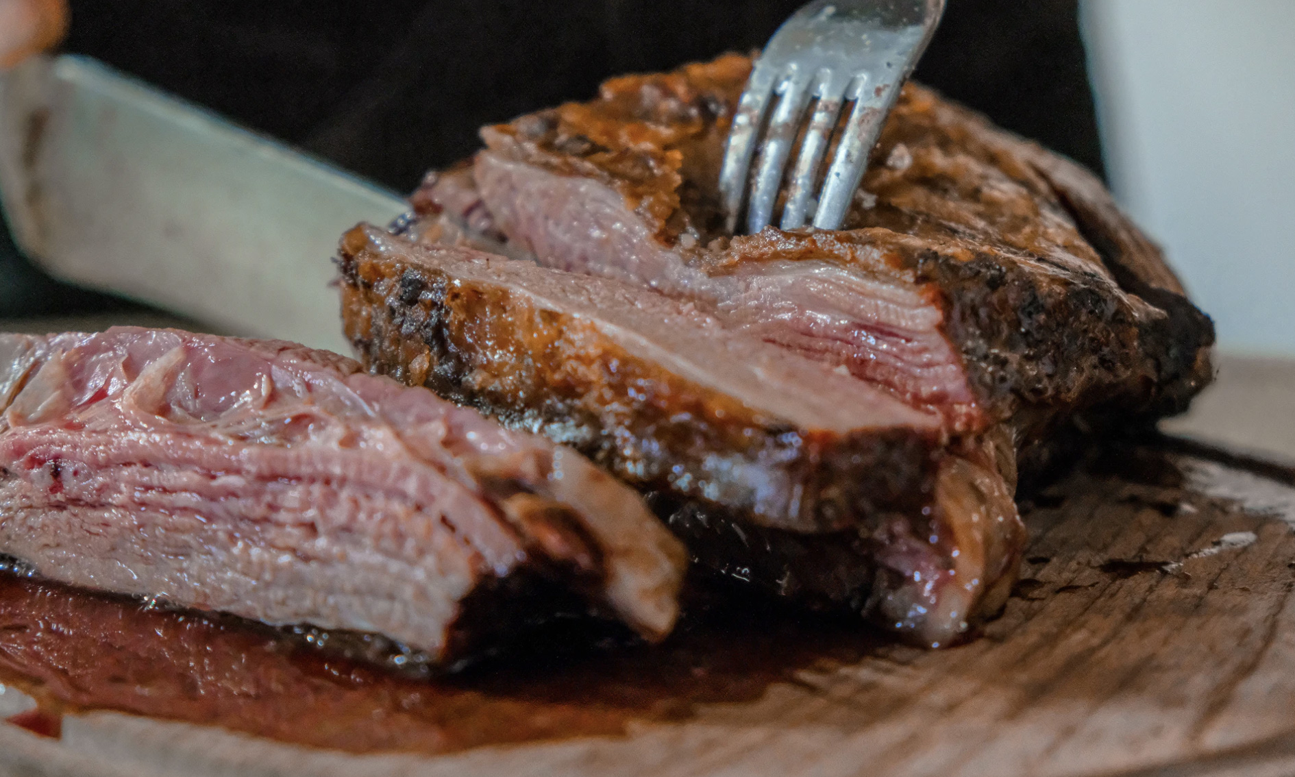 Person cutting up red meat