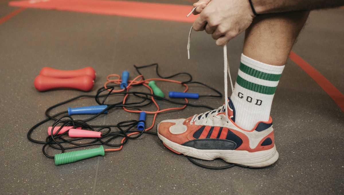 Man with gym equipment dumbbells and jump rope