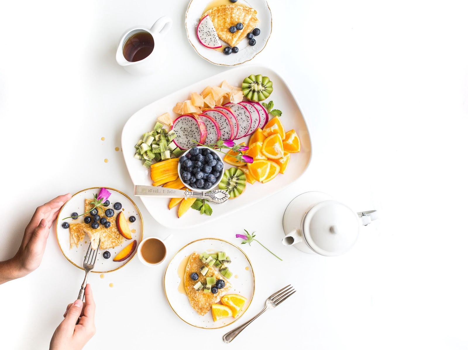 Plates full of dragonfruit, oranges and blueberries 