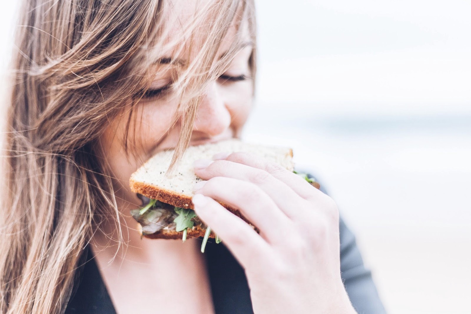 A girl eating a sandwich mindfully