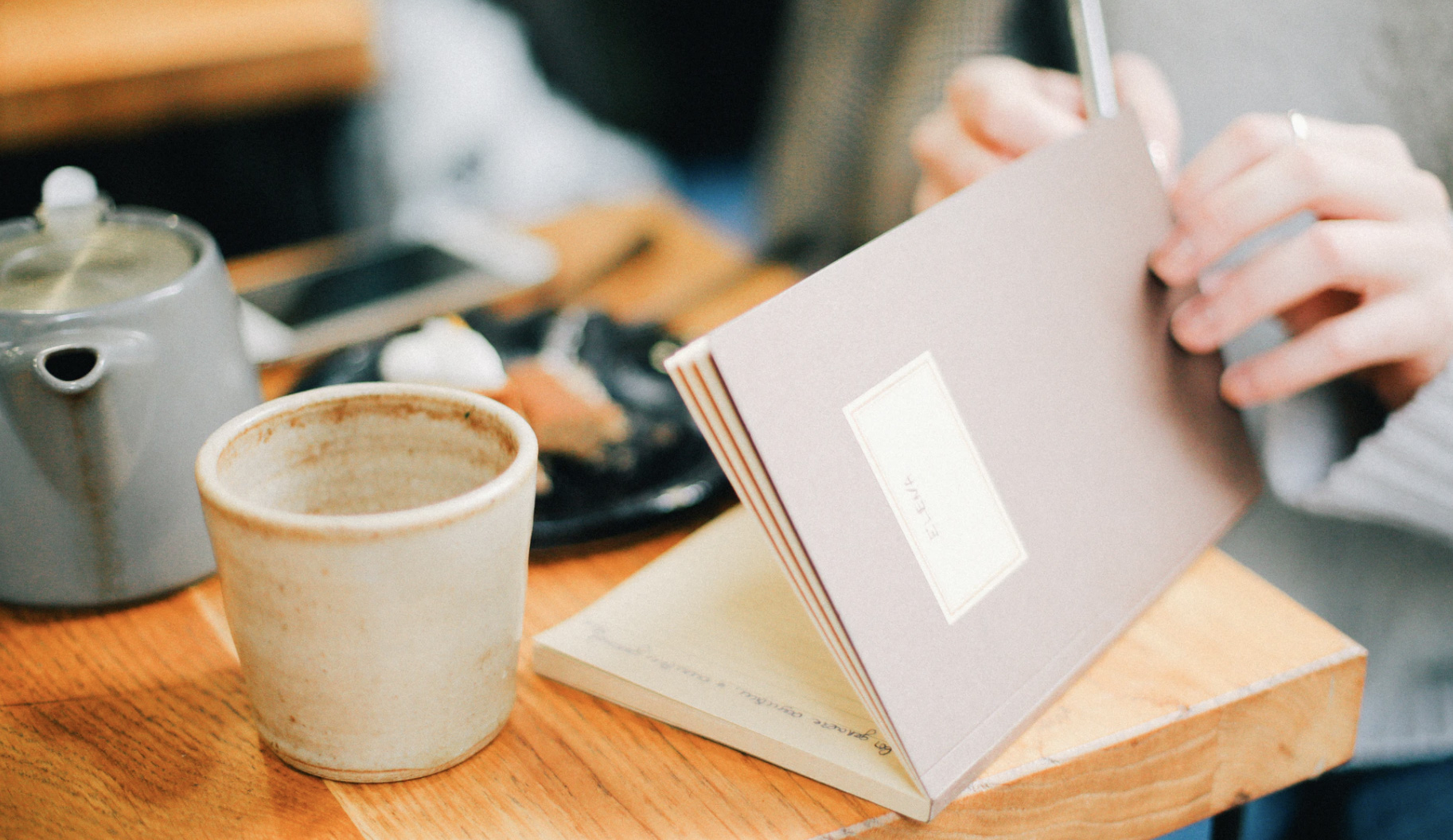 Woman journaling at table with coffee