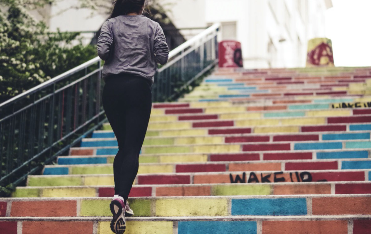 Female running up the stairs for her daily movement 