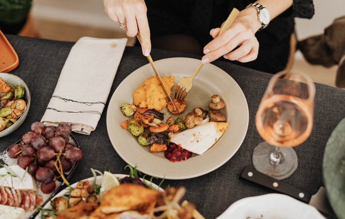 Woman with a plate of colorful food. Image: Pexels - Karolina Grabowska