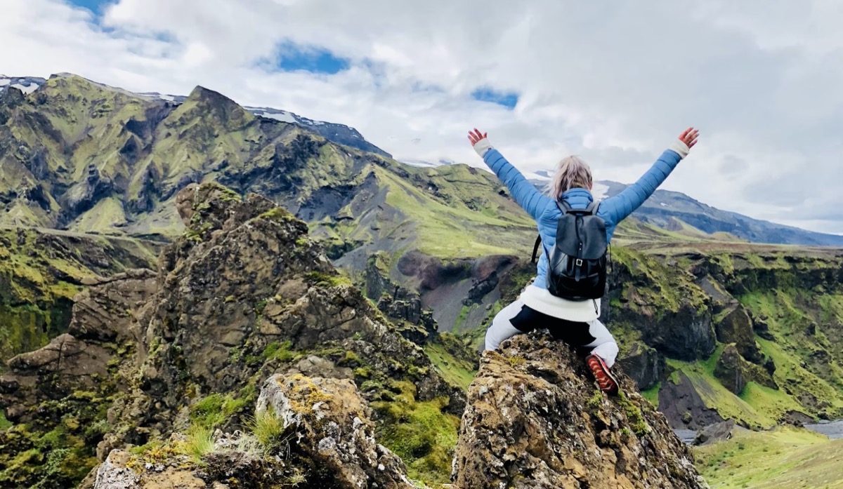 Excited woman on top of rocks 