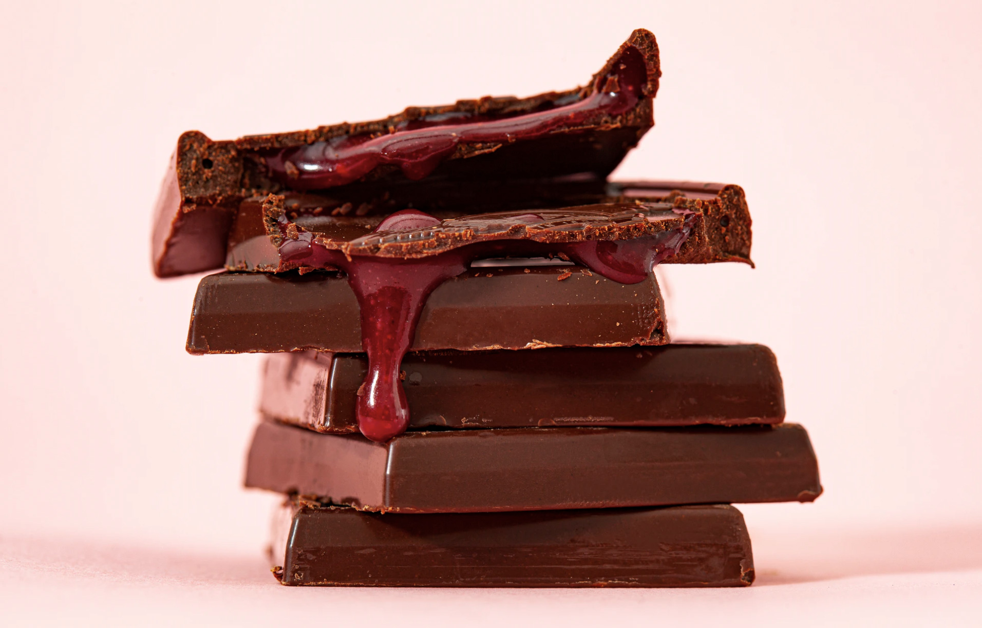 Chocolates stacked on top of each other with raspberry filling. 