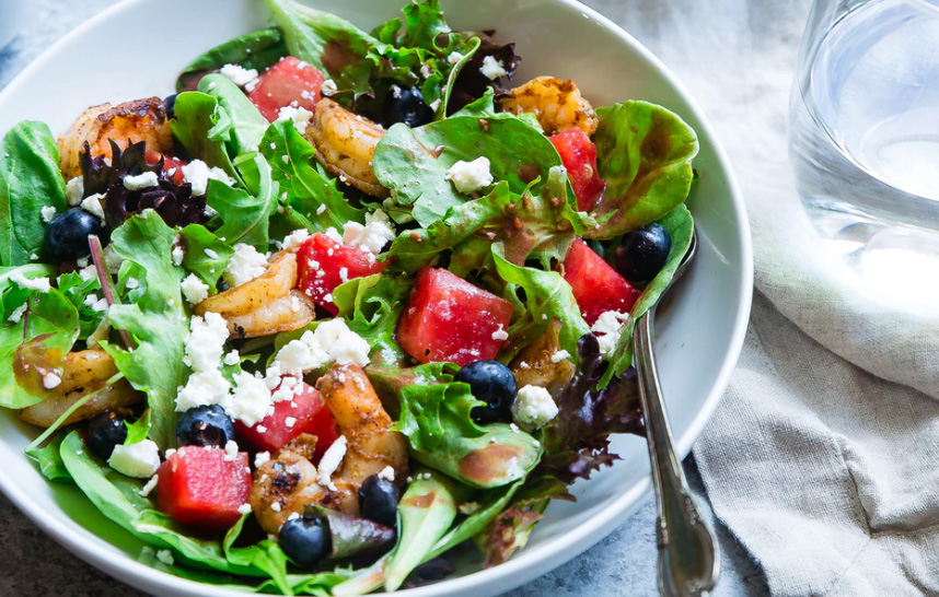 A green salad with fruits and vegetables