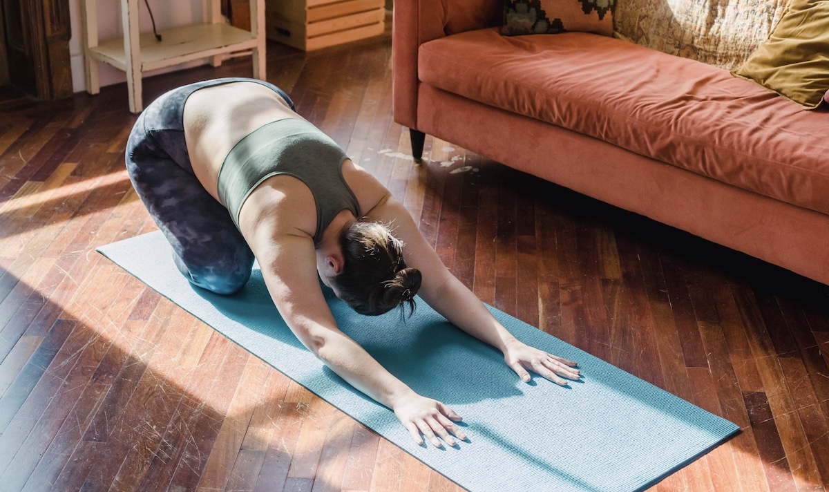 Woman doing yoga in bedroom